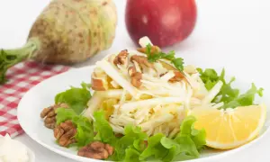 Wykwintna surówka z selera jak w restauracji, z jabłkiem, orzechami i cytryną, na tle selera i jabłka.