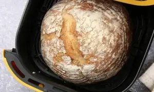 Chleb z airfryer, wypieczony na złoto, z chrupiącą skórką i mąką na wierzchu, gotowy do podania.