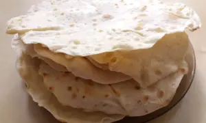 Stos świeżo upieczonych placków tortilla, które wyglądają jak z oryginalnego przepisu. Idealne do wrapów i quesadilli.