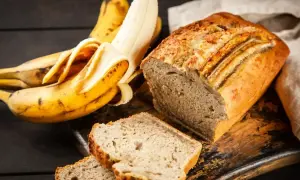 Wilgotne ciasto bananowe, pachnące i pyszne, obok dojrzałych bananów. Idealne na deser lub śniadanie.