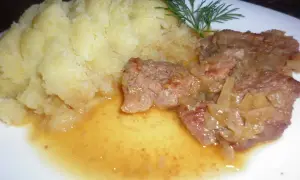 Pyszna cielęcina duszona w sosie własnym z puree ziemniaczanym i gałązką koperku.