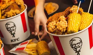 Kukurydza w KFC ma najmniej kalorii. Na zdjęciu kubełki z kurczakiem, frytki i kolby kukurydzy.