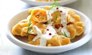 Pyszne pierogi z farszem, polane sosem śmietanowym i posypane koperkiem i pieprzem. Idealne co na piątkowy obiad!