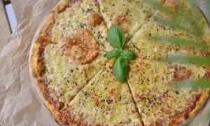 Pyszna pizza z rozpływającym się serem, ozdobiona listkiem bazylii. Idealny ser do pizzy, który zachwyca smakiem.