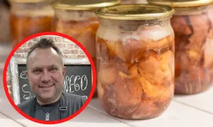 Uśmiechnięty mężczyzna obok słoików z domowym, pysznym mięsem w słoiku babci. Smak dzieciństwa zamknięty w słoiku.