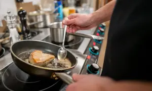 Szef kuchni delikatnie saute kawałek mięsa na patelni, tworząc apetyczną skórkę.