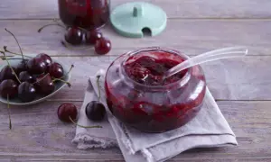 Ania gotuje konfiturę z wiśni. Słoik pełen pysznej, domowej konfitury z wiśni, obok świeże owoce.