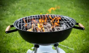Rozpalony grill węglowy z płomieniami, gotowy do grillowania. Idealny przykład, jak rozpalic grilla na letnie popołudnie.