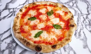 Idealne ciasto na pizzę neapolitańską z pomidorami, mozzarellą i bazylią.