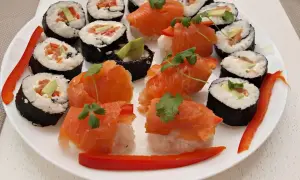 Talerz pełen pysznego sushi z łososiem, awokado i papryką. Idealne na wieczór, gdy masz ochotę na coś pysznego.
