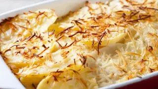 Zapiekanka ziemniaczana z serem, przypominająca danie raclette, w naczyniu żaroodpornym.