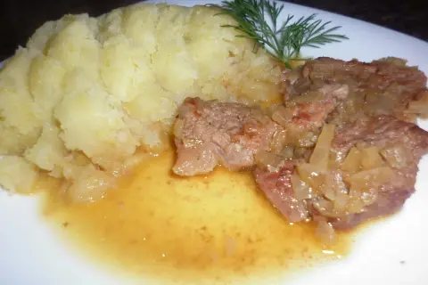Pyszna cielęcina duszona w sosie własnym z puree ziemniaczanym i gałązką koperku.
