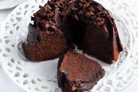 Pyszna babka z mascarpone i kakao, polana czekoladą i posypana wiórkami.