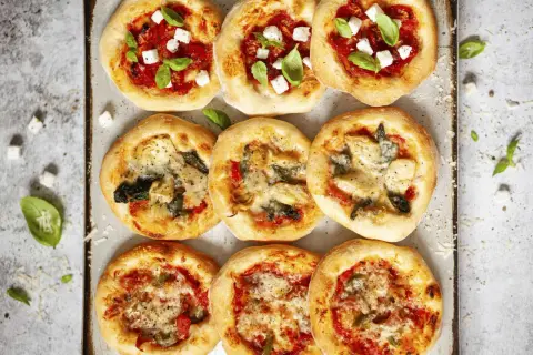 Mini pizze z serem feta i bazylią lub z karczochami i szpinakiem. Idealny przepis na ciasto do pizzy dla małych przysmaków.