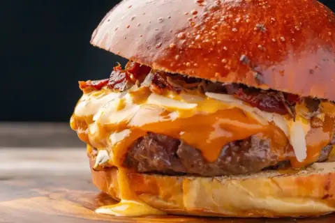 Soczysty burger z rozpływającym się serem i chrupiącym boczkiem. Zastanawiasz się, ile kalorii ma wieśmac? Ten wygląda na bogaty w smaku i kalorie!