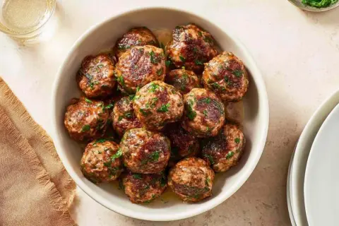 Pyszne kotlety mielone z airfryer, posypane świeżą natką pietruszki, gotowe do podania.