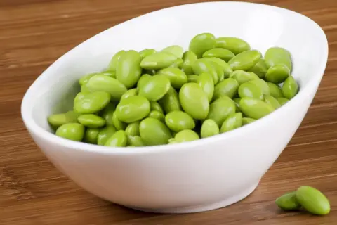 Miseczka pełna zielonych ziaren soi, czyli edamame. To zdrowa przekąska, która świetnie sprawdzi się jako dodatek do dań.