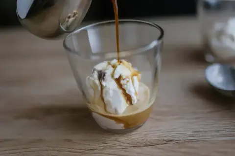Gorące espresso zalewa gałkę lodów waniliowych, tworząc pyszne affogato.