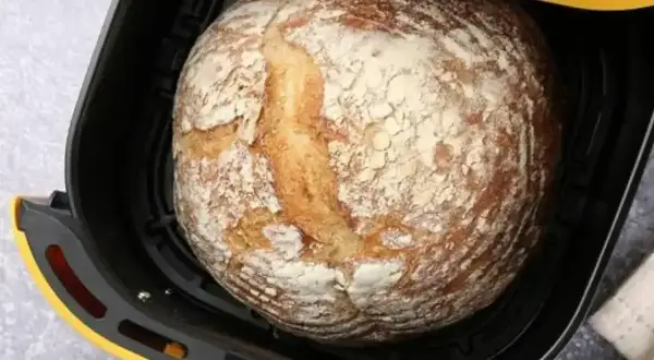 Chleb z airfryer, wypieczony na złoto, z chrupiącą skórką i mąką na wierzchu, gotowy do podania.