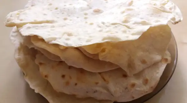 Stos świeżo upieczonych placków tortilla, które wyglądają jak z oryginalnego przepisu. Idealne do wrapów i quesadilli.
