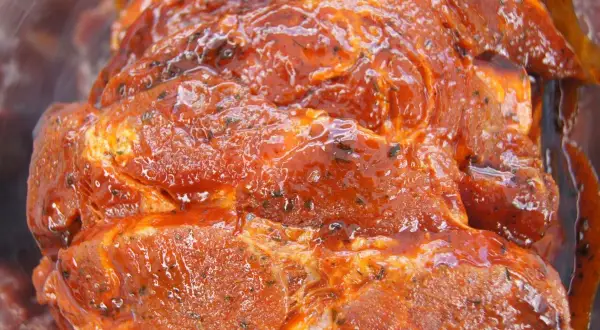 Soczyste mięso na grilla, zanurzone w aromatycznej, czerwonej marynacie z ziołami. Gotowe do pieczenia!