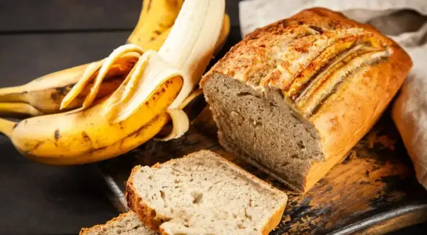 Wilgotne ciasto bananowe, pachnące i pyszne, obok dojrzałych bananów. Idealne na deser lub śniadanie.