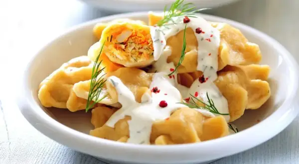 Pyszne pierogi z farszem, polane sosem śmietanowym i posypane koperkiem i pieprzem. Idealne co na piątkowy obiad!