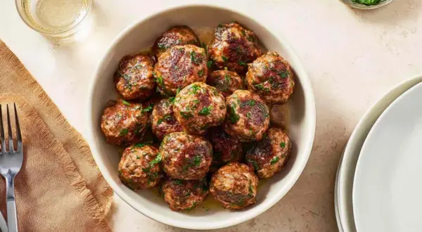 Pyszne kotlety mielone z airfryer, posypane świeżą natką pietruszki, gotowe do podania.
