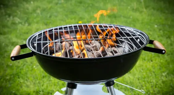 Rozpalony grill węglowy z płomieniami, gotowy do grillowania. Idealny przykład, jak rozpalic grilla na letnie popołudnie.