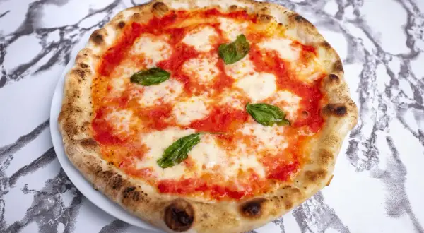 Idealne ciasto na pizzę neapolitańską z pomidorami, mozzarellą i bazylią.