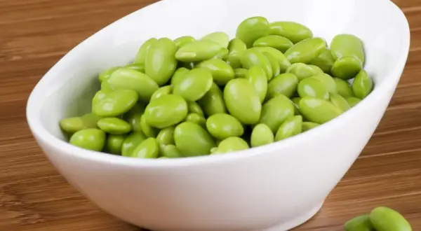 Miseczka pełna zielonych ziaren soi, czyli edamame. To zdrowa przekąska, która świetnie sprawdzi się jako dodatek do dań.