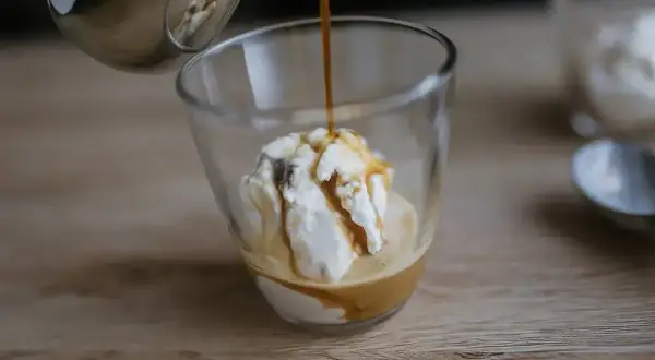 Gorące espresso zalewa gałkę lodów waniliowych, tworząc pyszne affogato.
