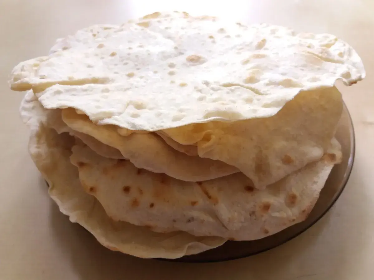Stos świeżo upieczonych placków tortilla, które wyglądają jak z oryginalnego przepisu. Idealne do wrapów i quesadilli.