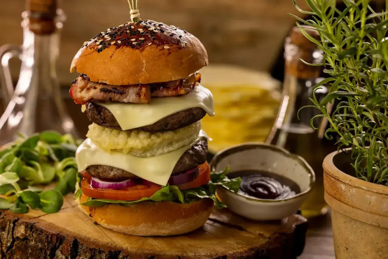 Potrójny burger z bekonem, serem, warzywami i chrupiącą cebulą. Idealny na prawdziwe burgery przepis.
