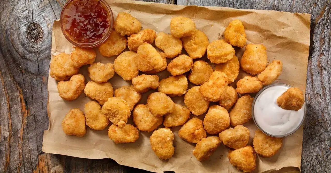 Chrupiące kawałki kurczaka w panierce, jak z oryginalnego przepisu KFC, z sosem czosnkowym i słodko-kwaśnym dipem.