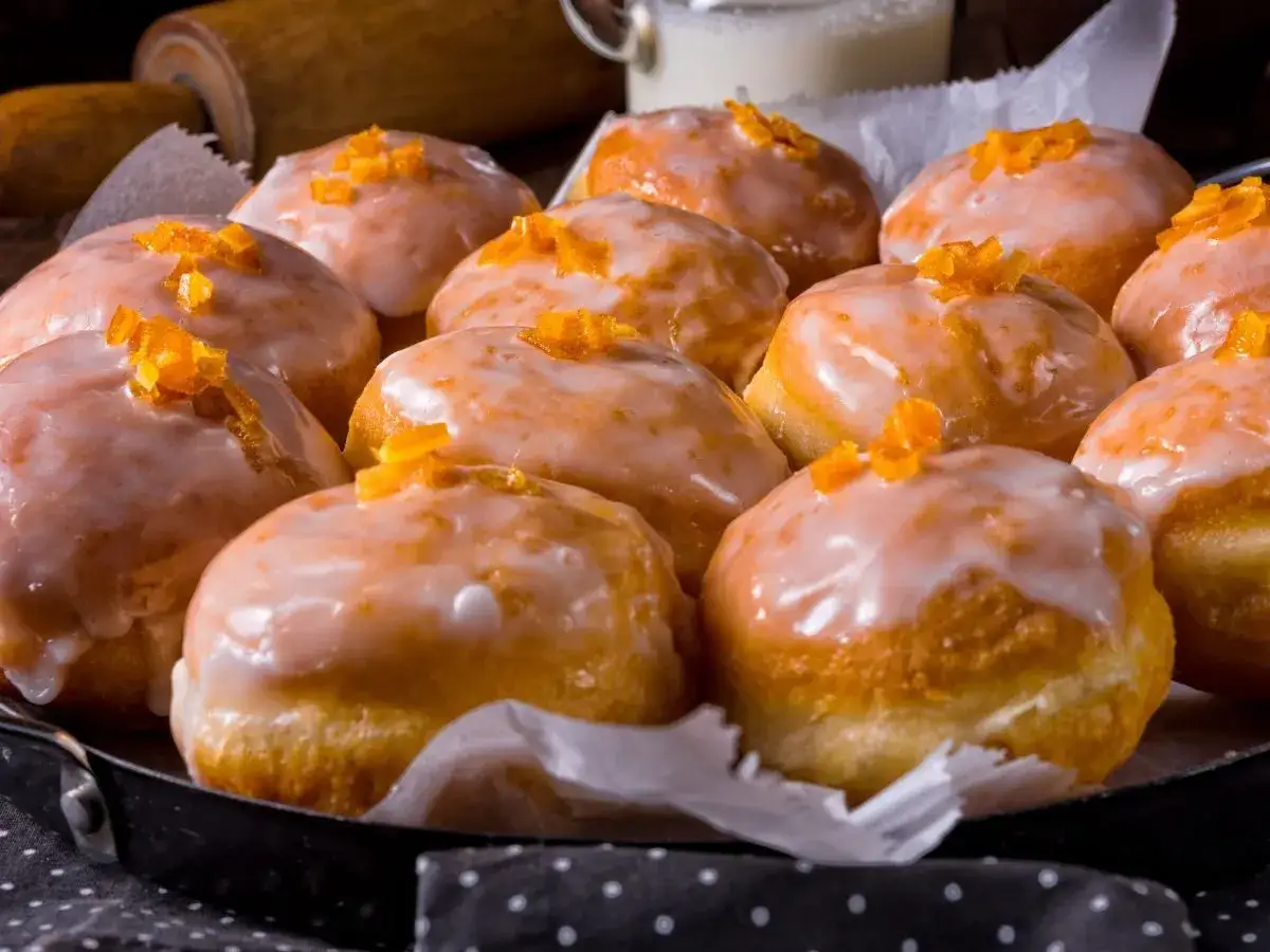 Pączki z ziemniakami Ewy Wachowicz, oblane lukrem i posypane skórką pomarańczową, wyglądają apetycznie.