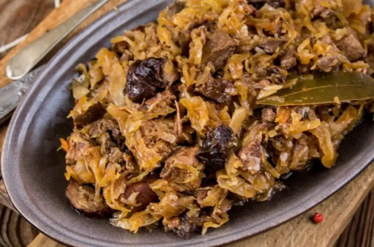 Tradycyjny polski bigos, bogaty w mięso i kapustę, z dodatkiem śliwek i liści laurowych. Przepisy mistrzów gwarantują niezapomniany smak.