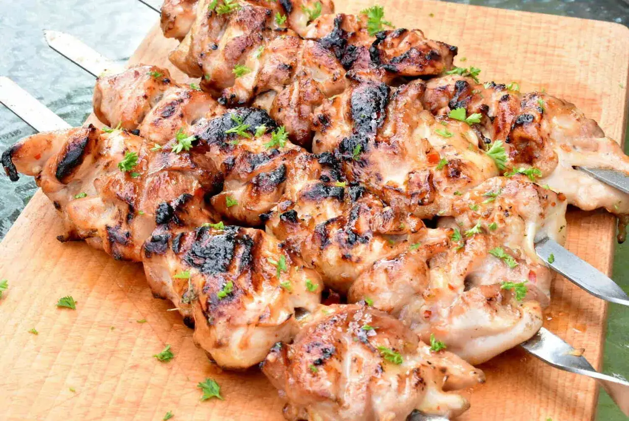 Szaszłyki z kurczaka z najlepszą marynatą, grillowane do perfekcji, posypane świeżą natką pietruszki.