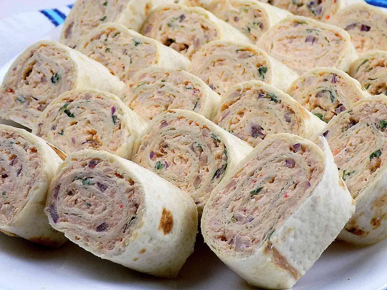 Szybkie przekąski z tortilli na zimno, pokrojone w krążki, z kremowym nadzieniem i ziołami. Idealne na imprezę!