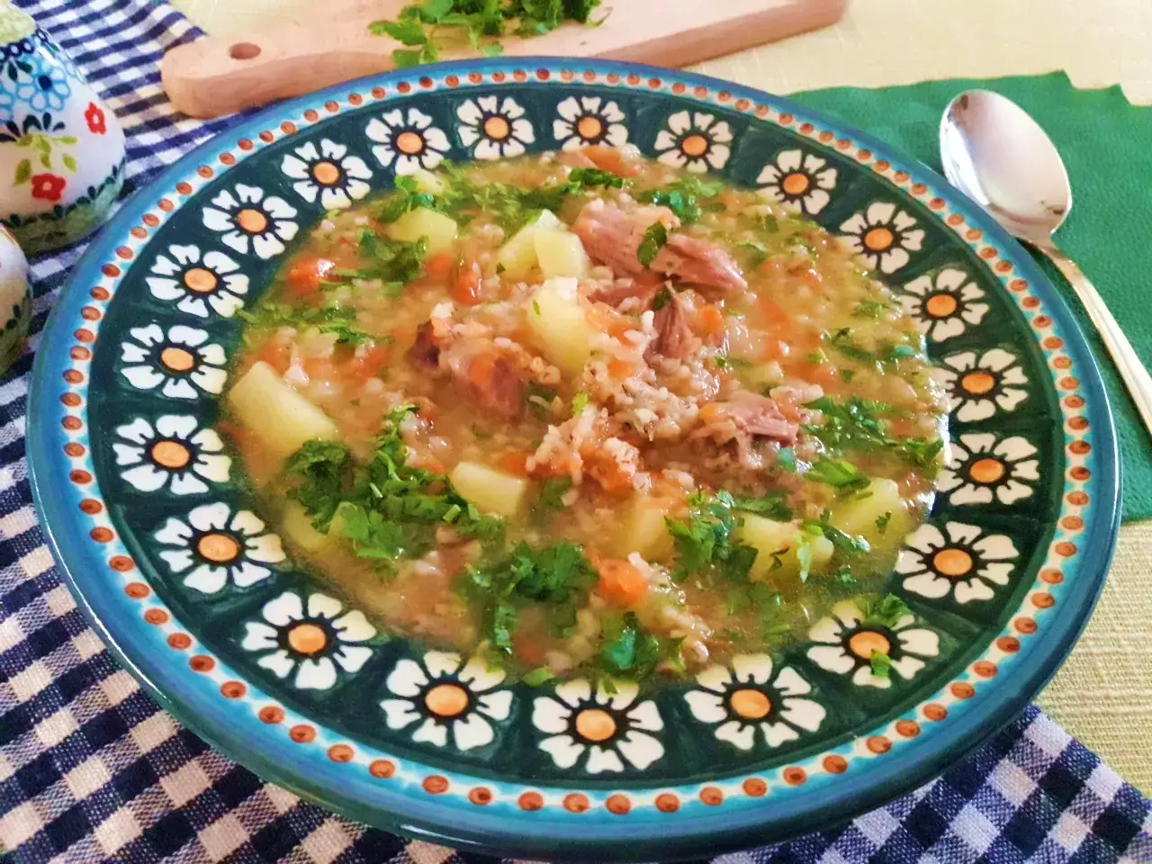 Jaka zupa na golonce wieprzowej? Aromatyczna, sycąca zupa z kawałkami golonki, ziemniakami, marchewką i ryżem, posypana natką pietruszki.