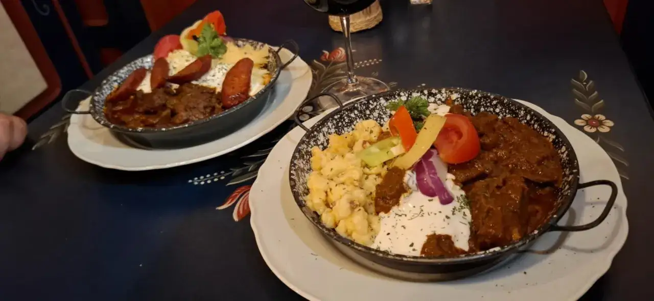 Dwa sycące węgierskie dania, gulasz i kluseczki, wyglądają na pyszne. Ciekawe, ile forintów kosztuje obiad na Węgrzech.