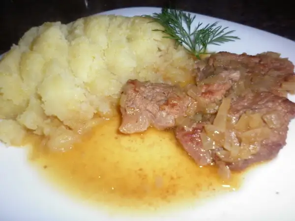 Pyszna cielęcina duszona w sosie własnym z puree ziemniaczanym i gałązką koperku.