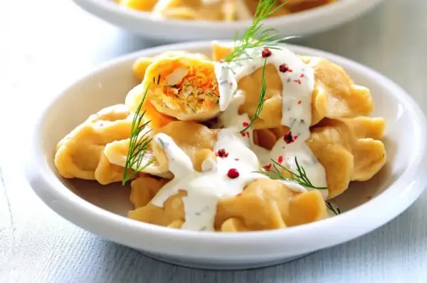 Pyszne pierogi z farszem, polane sosem śmietanowym i posypane koperkiem i pieprzem. Idealne co na piątkowy obiad!
