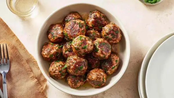Pyszne kotlety mielone z airfryer, posypane świeżą natką pietruszki, gotowe do podania.