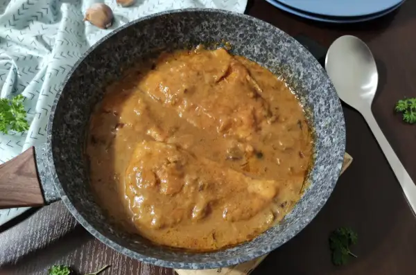 Bitki z indyka w sosie własnym, gotowe do podania. Aromatyczne danie w patelni, ozdobione natką pietruszki.