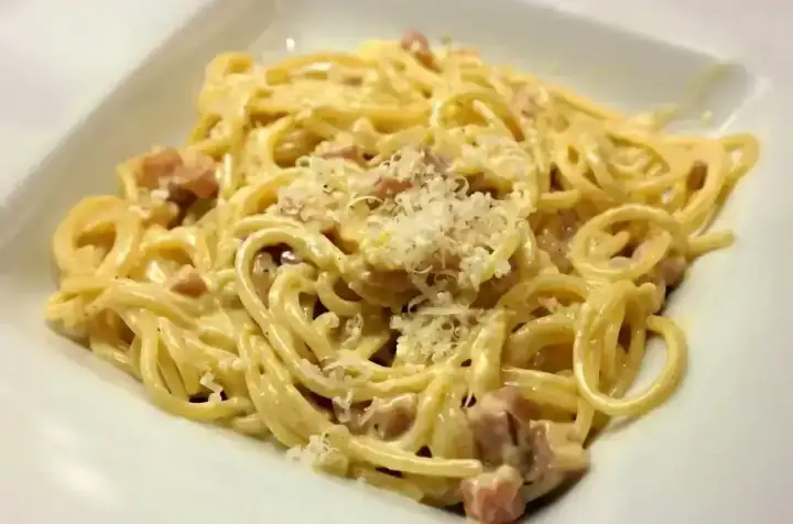Pyszna carbonara z kawałkami guanciale i startym parmezanem. Idealny ser do carbonary to klucz do sukcesu!